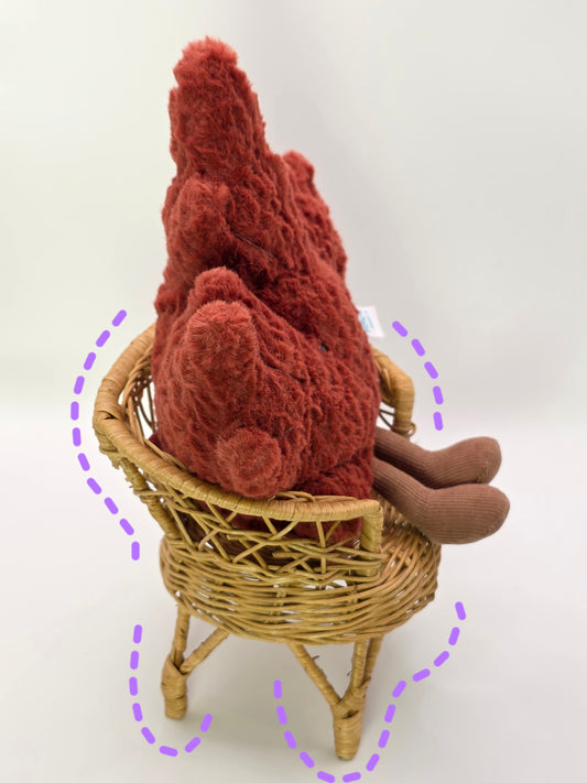 stuffed animal on a small wicker chair with a white background