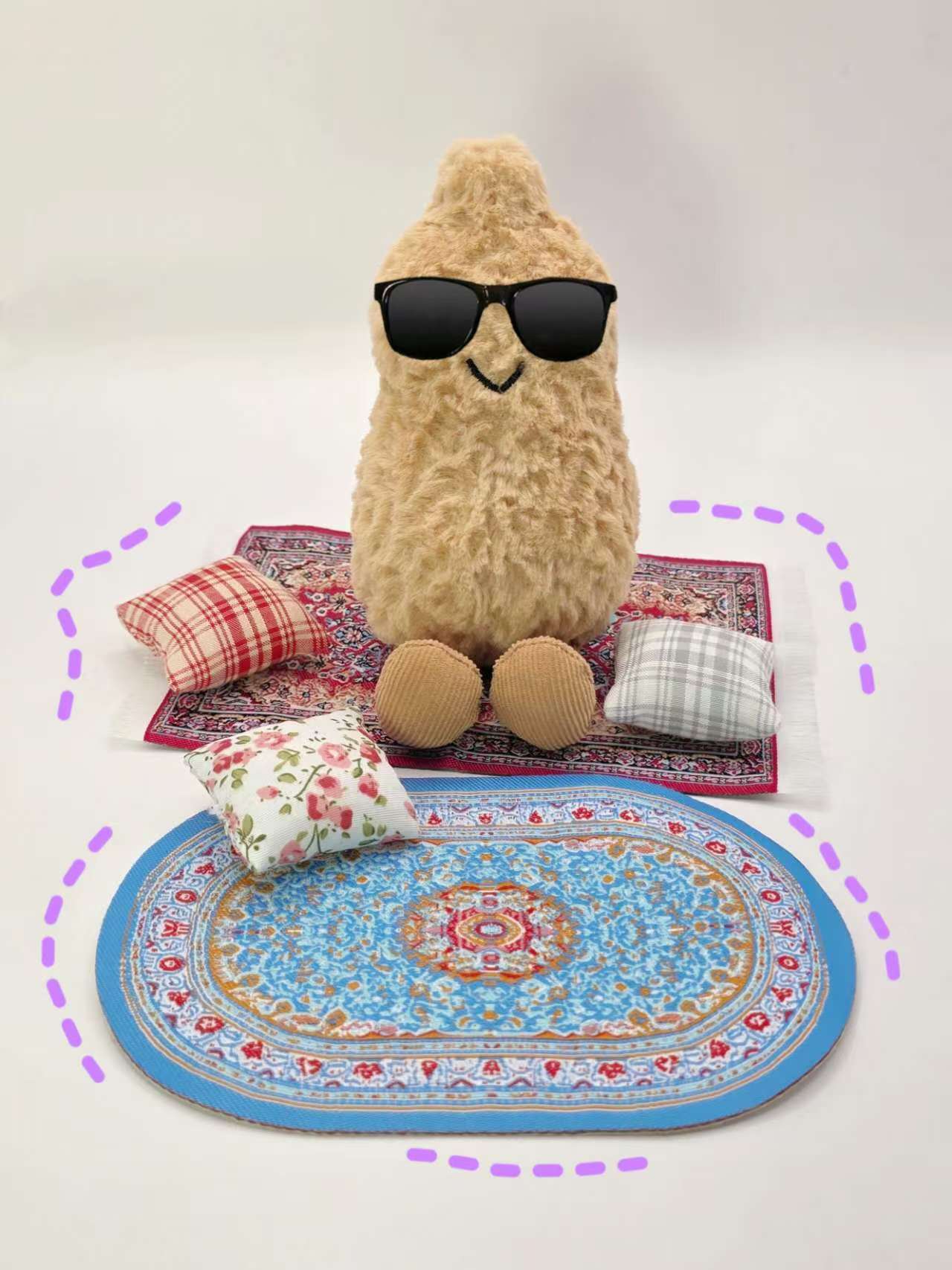 stuffed animal wearing sunglasses on a colorful rug with pillows.