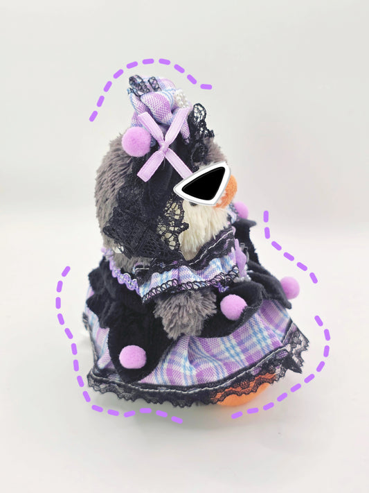 Stuffed animal toy with a dress and sunglasses on a white background