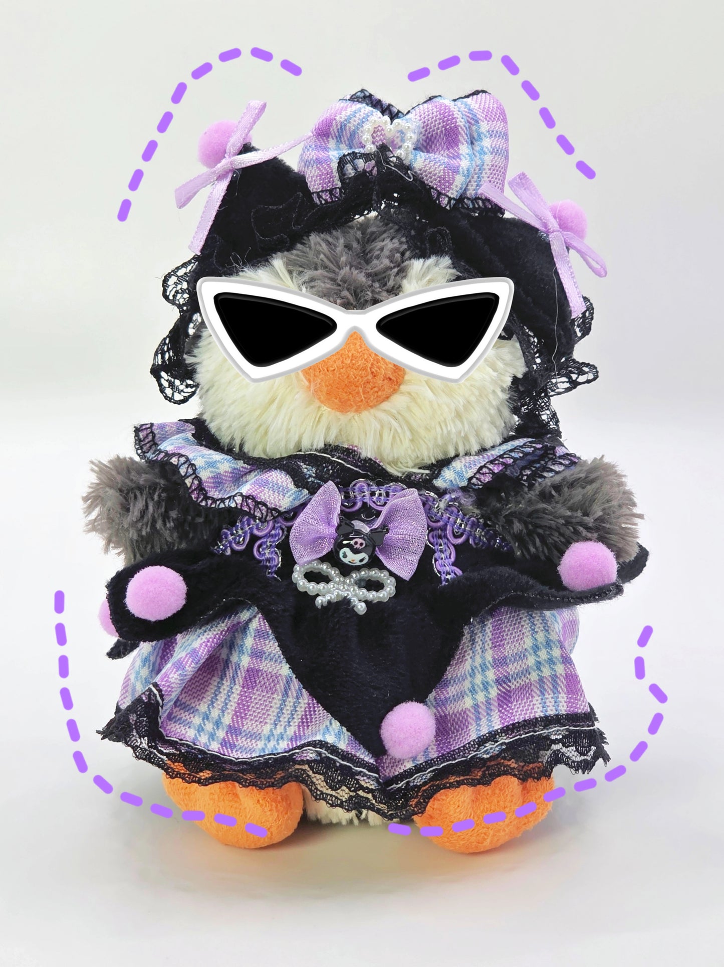 Stuffed toy penguin wearing sunglasses, a purple dress with black lace, and a bow on a white background.