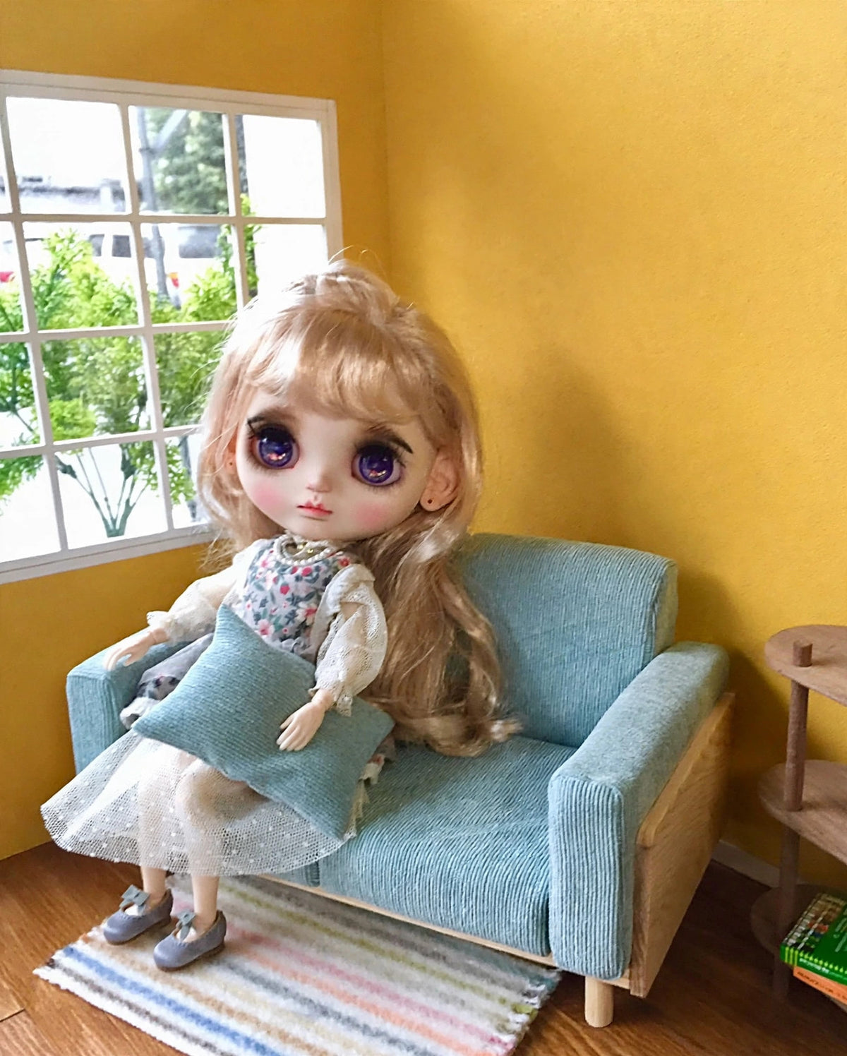 Blue-gray miniature doll sofa with doll, no text overlay