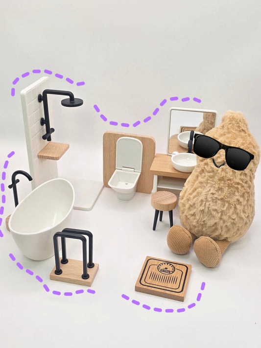 Miniature bathroom set with stuffed animal wearing sunglasses on a white background